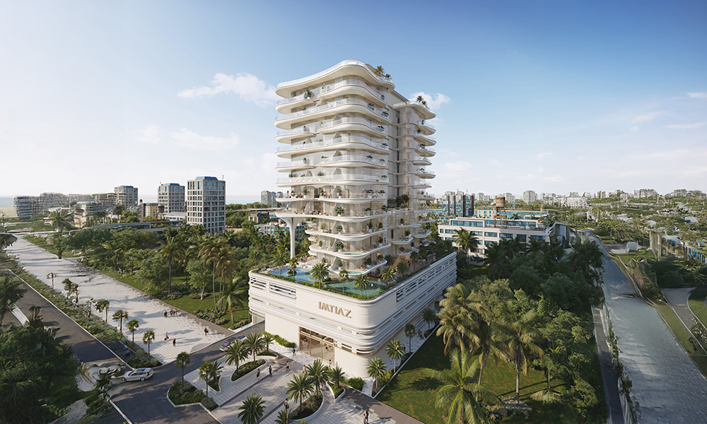 Beach Walk Iii By Imtiaz A modern multi-story building surrounded by greenery, with palm trees and pathways, in a sunny urban environment.